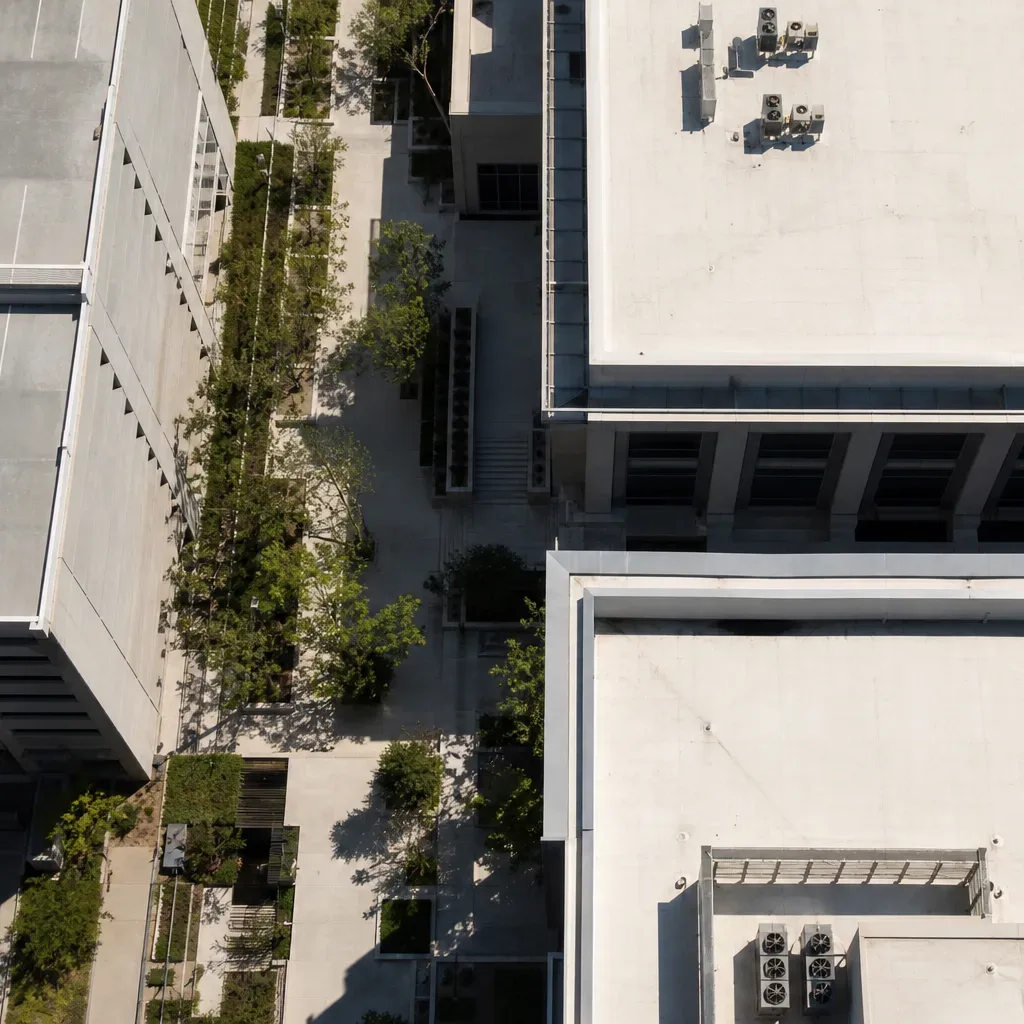 A suburban Austin office corridor shows a row of low-rise buildings along a landscaped business-park drive