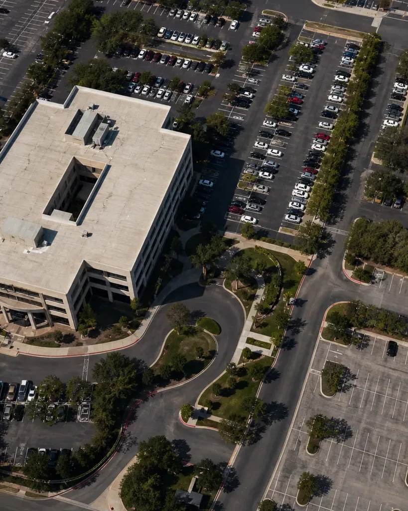A glass-curtain-wall office tower rises along a downtown Austin block