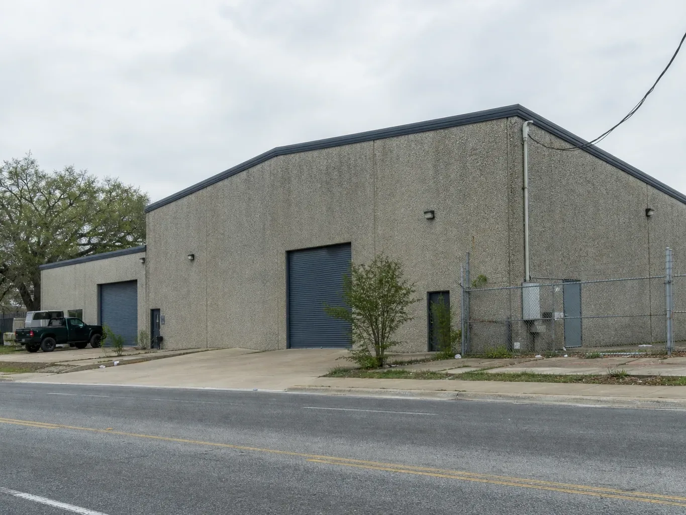 A tilt-wall light industrial building in an East Austin Opportunity Zone corridor is viewed from the street
