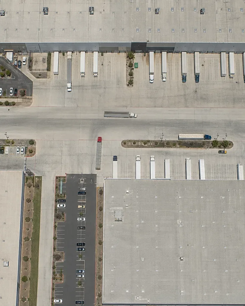 A broad tilt-wall warehouse facade extends along a suburban Austin industrial drive